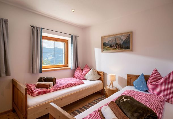 Schlafzimmer mit zwei Einzelbetten und Fenster mit Bergblick
