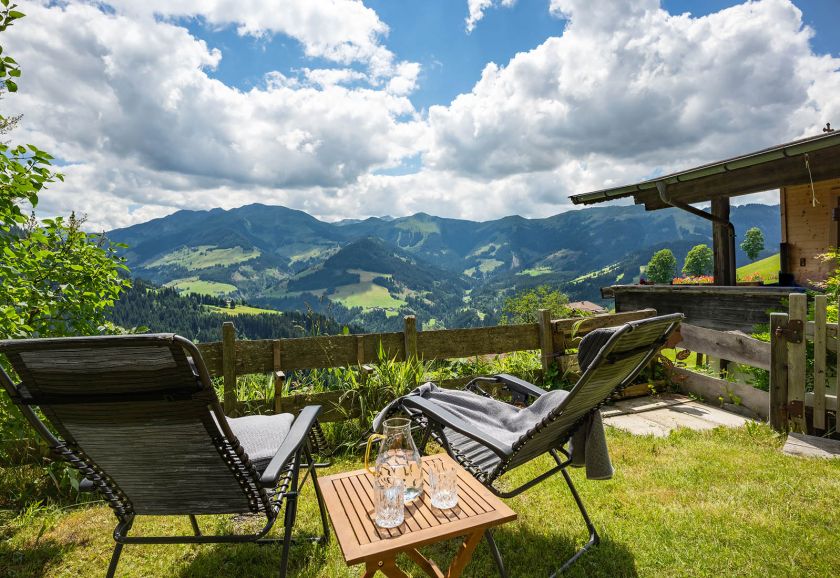 Liegestühle im Garten mit weitem Blick auf die umliegenden Berge